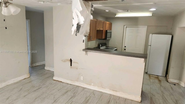 1524 NE 31st Ct, Pompano Beach, FL 33064 - kitchen featuring freestanding refrigerator, electric stove, brown cabinetry, dark countertops, and stainless steel microwave