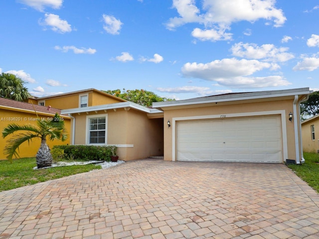 798 Quartz Ter, Palm Beach, FL 33413 - view of front facade with stucco siding, decorative driveway, and an attached garage