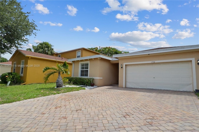 798 Quartz Ter, Palm Beach, FL 33413 - view of front of property featuring stucco siding, decorative driveway, and a garage