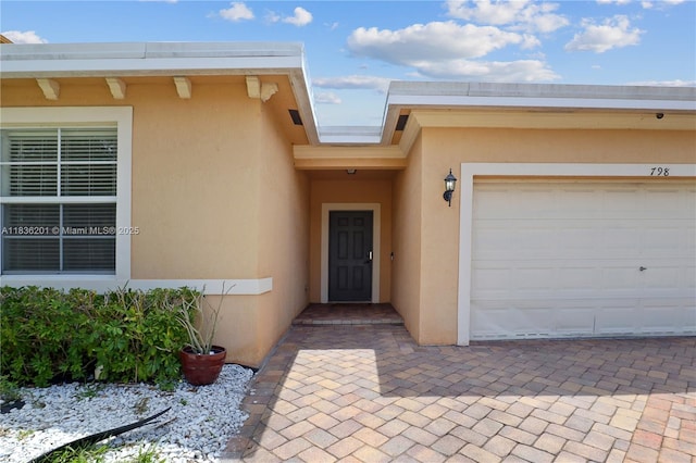 798 Quartz Ter, Palm Beach, FL 33413 - view of exterior entry featuring stucco siding and an attached garage