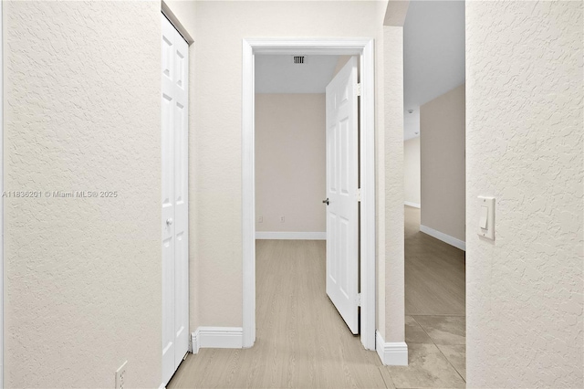 798 Quartz Ter, Palm Beach, FL 33413 - hall with a textured wall and light wood-style floors