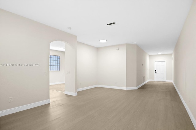 798 Quartz Ter, Palm Beach, FL 33413 - empty room with arched walkways, light wood-style flooring, and a smoke detector