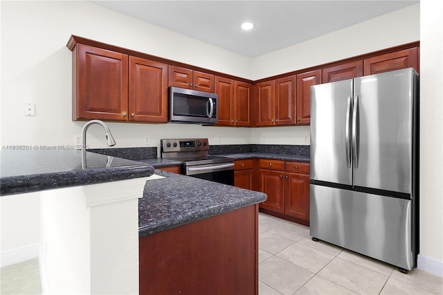 798 Quartz Ter, Palm Beach, FL 33413 - kitchen with appliances with stainless steel finishes, a peninsula, light tile patterned flooring, dark stone countertops, and recessed lighting