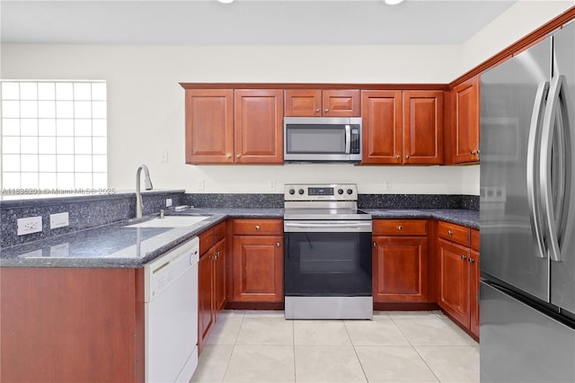 798 Quartz Ter, Palm Beach, FL 33413 - kitchen with appliances with stainless steel finishes, a peninsula, light tile patterned floors, and dark stone countertops