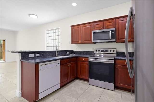 798 Quartz Ter, Palm Beach, FL 33413 - kitchen with stainless steel appliances, light tile patterned flooring, a peninsula, and dark stone counters