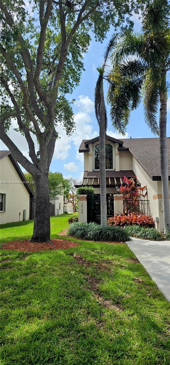 10194 SW 137th Ct Unit 10194, Miami, FL 33186 - view of property exterior featuring stucco siding and a lawn