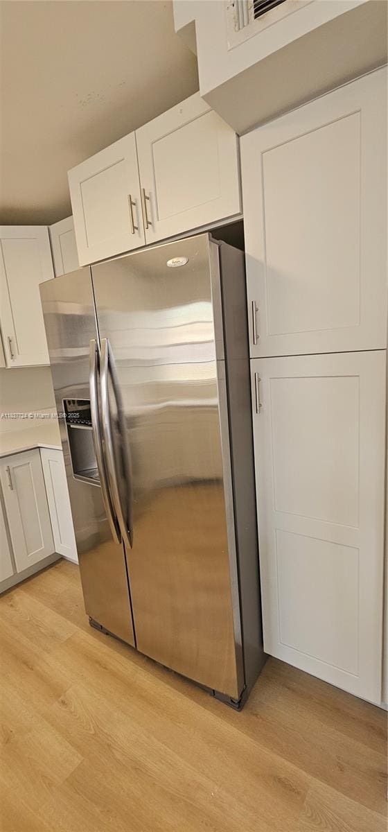 10194 SW 137th Ct Unit 10194, Miami, FL 33186 - kitchen with stainless steel fridge with ice dispenser, light wood-style floors, white cabinets, and light countertops