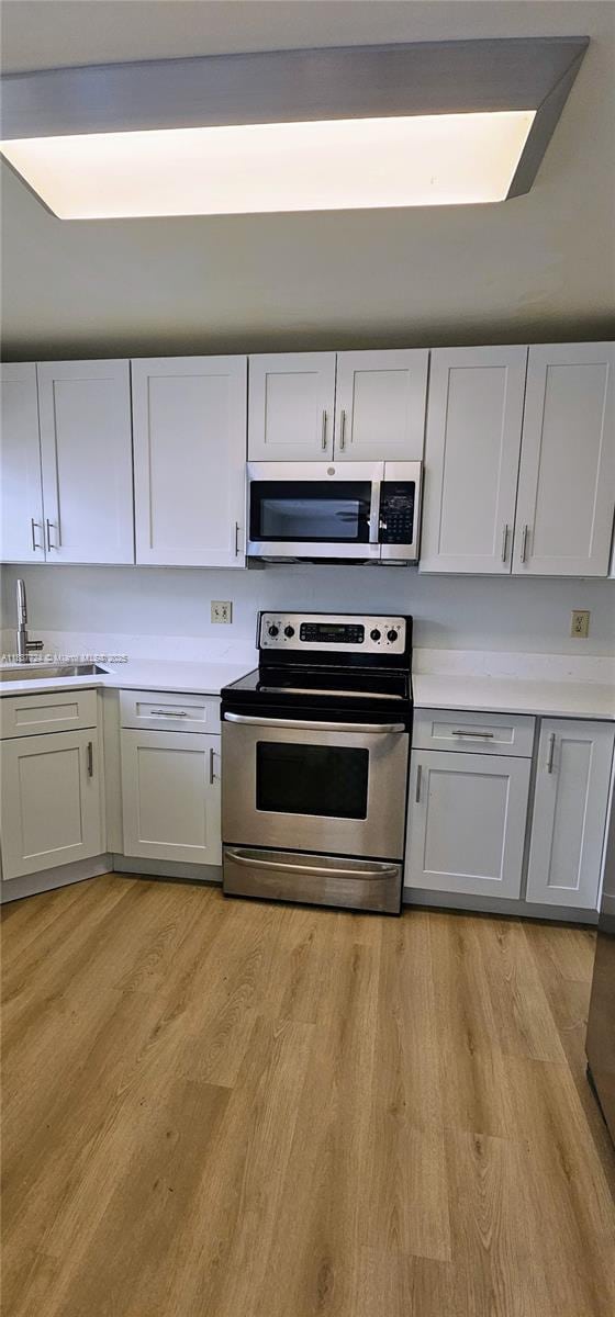 10194 SW 137th Ct Unit 10194, Miami, FL 33186 - kitchen featuring stainless steel appliances, light wood finished floors, and light countertops