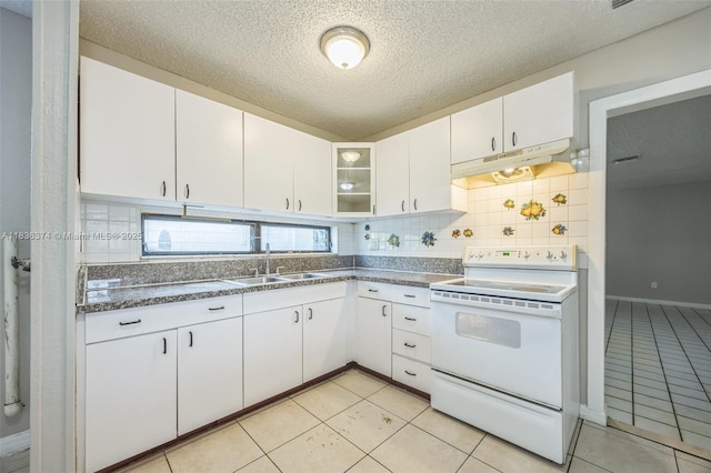 1160 NW 47th Ave, Lauderhill, FL 33313 - kitchen with white range with electric stovetop, backsplash, under cabinet range hood, white cabinets, and dark countertops