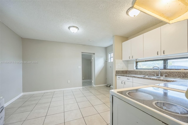 1160 NW 47th Ave, Lauderhill, FL 33313 - kitchen with white electric range, white cabinetry, light tile patterned flooring, dark countertops, and a textured ceiling