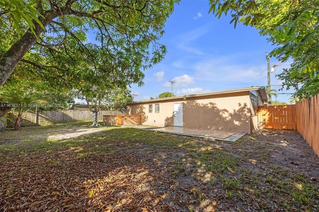 1160 NW 47th Ave, Lauderhill, FL 33313 - back of house with stucco siding, a fenced backyard, and a patio