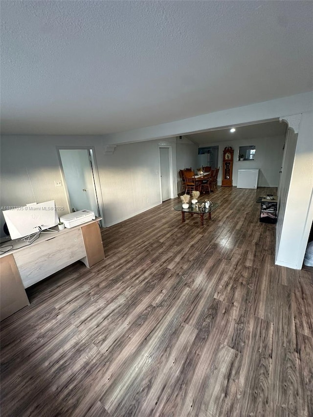 living area with dark wood-style floors and a textured ceiling