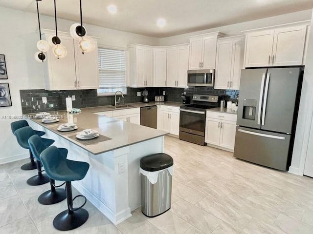 9338 Sommerset Hls, Kissimmee, FL 33896 - kitchen with stainless steel appliances, a peninsula, backsplash, white cabinetry, and a kitchen breakfast bar
