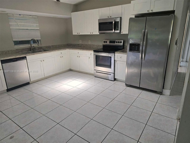 1744 SE Berkshire Blvd, Port St Lucie, FL 34952 - kitchen featuring appliances with stainless steel finishes, white cabinetry, light tile patterned floors, and light stone counters