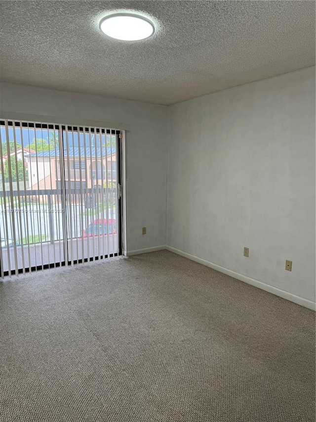 18240 Mediterranean Blvd Unit 5-11, Hialeah, FL 33015 - carpeted empty room with a textured ceiling and baseboards