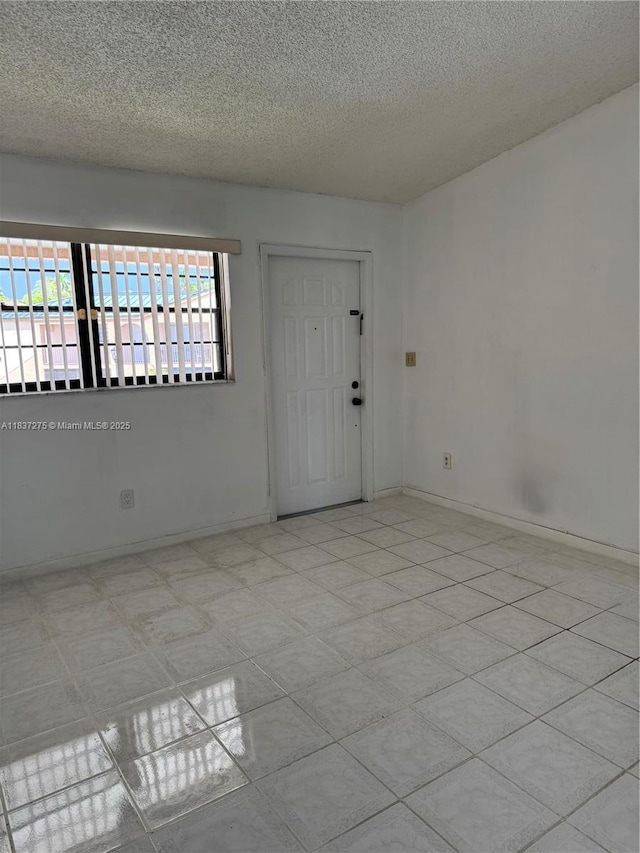18240 Mediterranean Blvd Unit 5-11, Hialeah, FL 33015 - empty room with a textured ceiling and baseboards