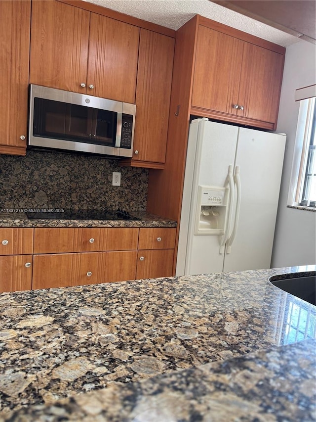 18240 Mediterranean Blvd Unit 5-11, Hialeah, FL 33015 - kitchen featuring stainless steel microwave, white fridge with ice dispenser, dark stone countertops, and a textured ceiling