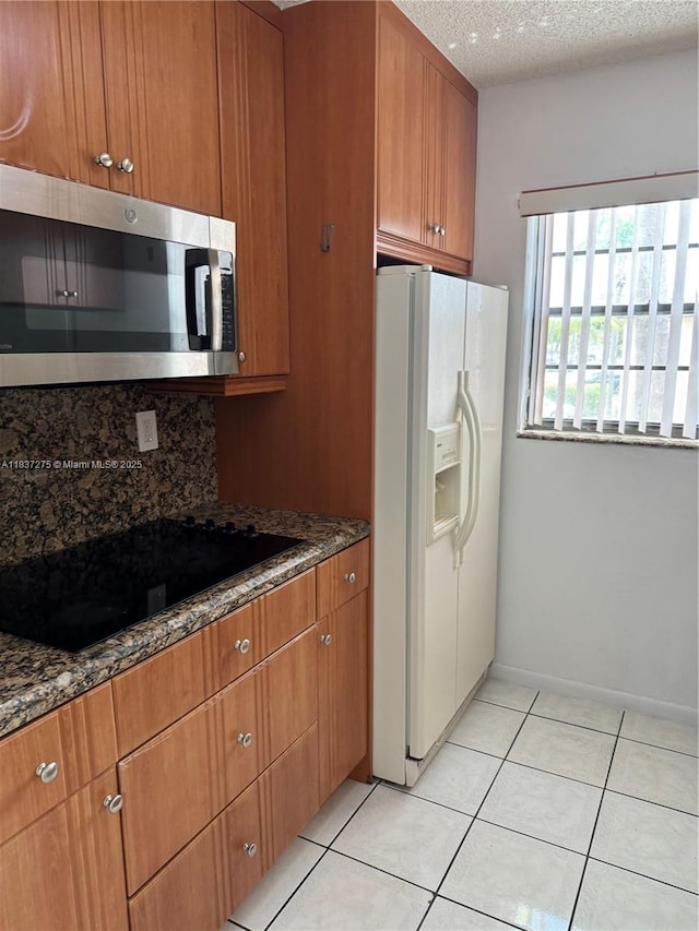 18240 Mediterranean Blvd Unit 5-11, Hialeah, FL 33015 - kitchen featuring stainless steel microwave, white refrigerator with ice dispenser, black electric stovetop, backsplash, and brown cabinetry