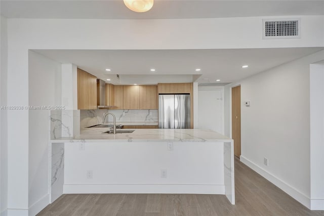 5600 Collins Ave Unit 10L, Miami Beach, FL 33140 - kitchen featuring freestanding refrigerator, a peninsula, light wood-type flooring, recessed lighting, and tasteful backsplash