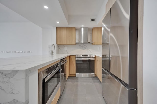 5600 Collins Ave Unit 10L, Miami Beach, FL 33140 - kitchen featuring stainless steel appliances, wall chimney range hood, modern cabinets, a peninsula, and light brown cabinets