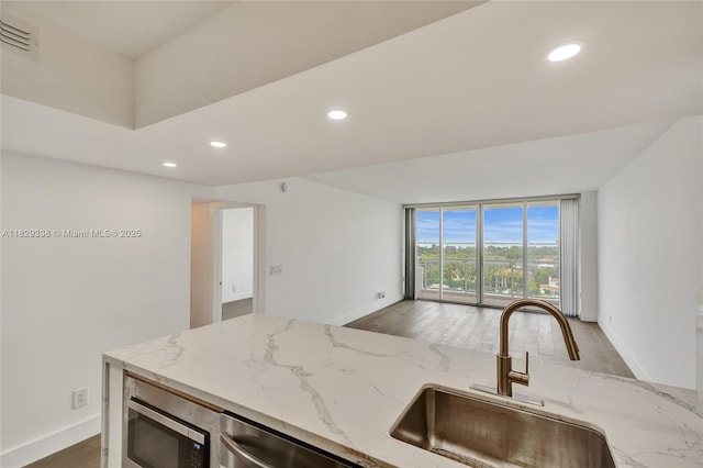 5600 Collins Ave Unit 10L, Miami Beach, FL 33140 - kitchen featuring appliances with stainless steel finishes, recessed lighting, wood finished floors, light stone countertops, and open floor plan