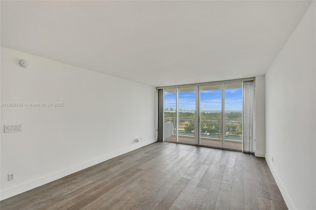 5600 Collins Ave Unit 10L, Miami Beach, FL 33140 - empty room with floor to ceiling windows, wood finished floors, and a smoke detector