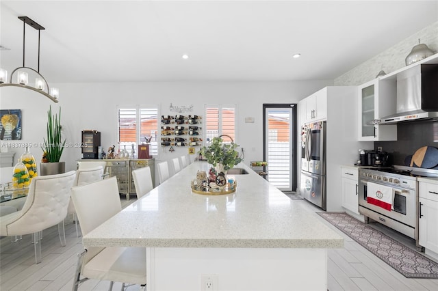 8236 SW 36th St, Miami, FL 33155 - kitchen featuring stainless steel appliances, wall chimney range hood, healthy amount of natural light, a kitchen island with sink, and recessed lighting