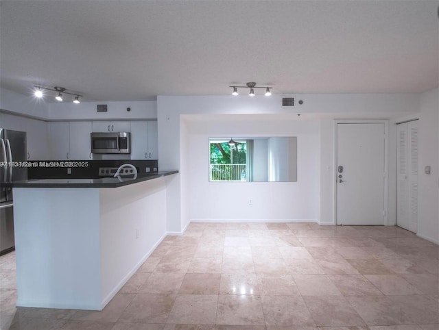 19501 E Country Club Dr Unit 9306, Aventura, FL 33180 - kitchen with appliances with stainless steel finishes, rail lighting, dark countertops, and a peninsula
