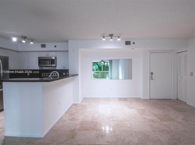 19501 E Country Club Dr Unit 9306, Aventura, FL 33180 - kitchen with appliances with stainless steel finishes, track lighting, dark countertops, and a peninsula