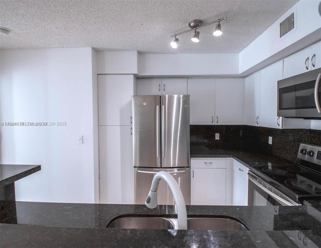 19501 E Country Club Dr Unit 9306, Aventura, FL 33180 - kitchen featuring stainless steel appliances, dark stone countertops, a textured ceiling, decorative backsplash, and white cabinetry