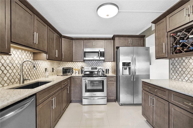 12650 SW 6th St Unit 101K, Pembroke Pines, FL 33027 - kitchen with stainless steel appliances, light stone counters, dark brown cabinets, tasteful backsplash, and ornamental molding