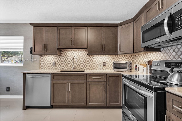 12650 SW 6th St Unit 101K, Pembroke Pines, FL 33027 - kitchen with stainless steel appliances, dark brown cabinetry, a textured ceiling, ornamental molding, and light stone counters
