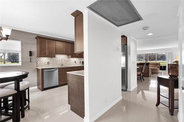 12650 SW 6th St Unit 101K, Pembroke Pines, FL 33027 - kitchen with stainless steel appliances, light tile patterned flooring, dark brown cabinetry, decorative backsplash, and recessed lighting