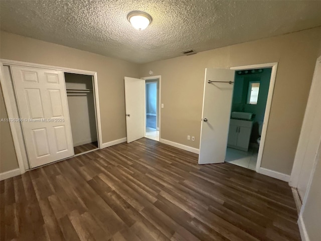 2307 Rodman St, Hollywood, FL 33020 - unfurnished bedroom featuring a closet, dark wood-type flooring, a textured ceiling, and ensuite bathroom