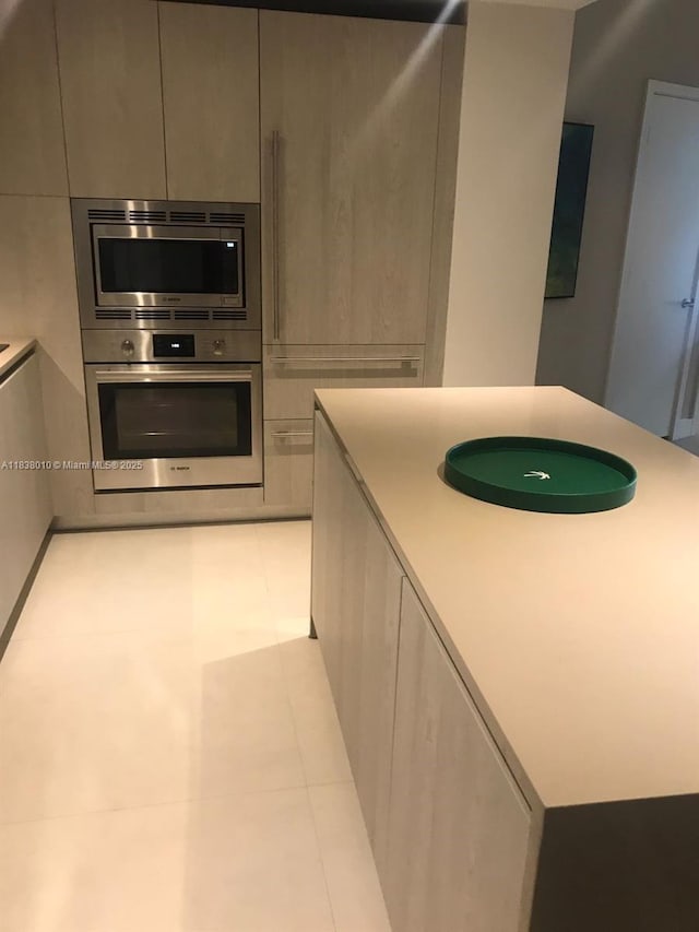 4111 S Ocean Dr Unit 3105, Hollywood, FL 33019 - kitchen featuring stainless steel appliances, modern cabinets, light tile patterned flooring, light countertops, and a center island