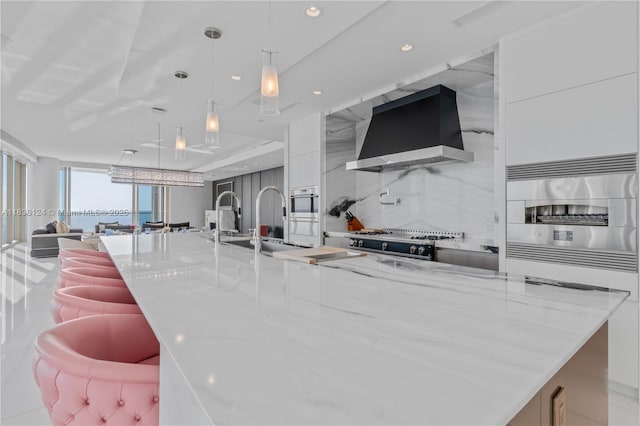 17975 Collins Ave Unit 1202, Sunny Isles Beach, FL 33160 - kitchen featuring wall chimney exhaust hood, modern cabinets, stove, white cabinetry, and light stone counters