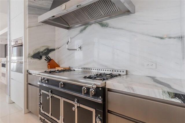 17975 Collins Ave Unit 1202, Sunny Isles Beach, FL 33160 - kitchen with premium range hood, decorative backsplash, oven, cooktop, and light stone countertops