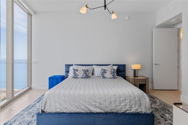 17975 Collins Ave Unit 1202, Sunny Isles Beach, FL 33160 - bedroom featuring multiple windows, wood finished floors, and a water view
