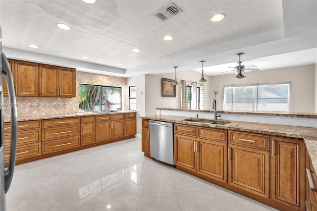 911 Mockingbird Ln, Plantation, FL 33324 - kitchen with stainless steel appliances, brown cabinetry, decorative backsplash, light stone counters, and ceiling fan