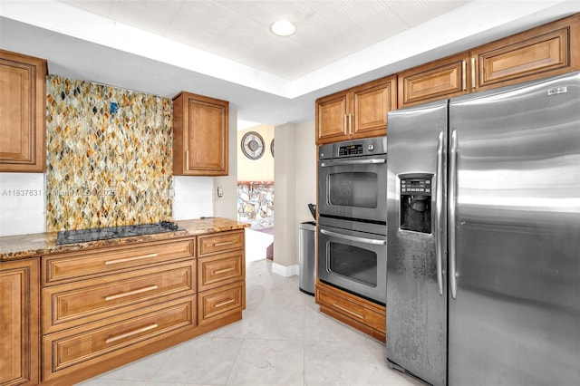 911 Mockingbird Ln, Plantation, FL 33324 - kitchen with appliances with stainless steel finishes, brown cabinets, light stone countertops, and a raised ceiling