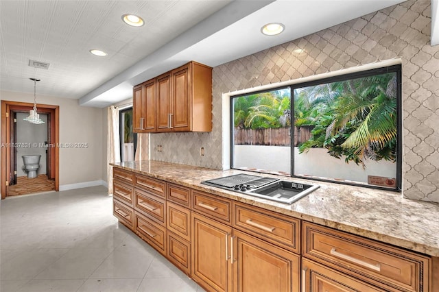 911 Mockingbird Ln, Plantation, FL 33324 - kitchen featuring stovetop with downdraft, brown cabinetry, light stone countertops, and recessed lighting