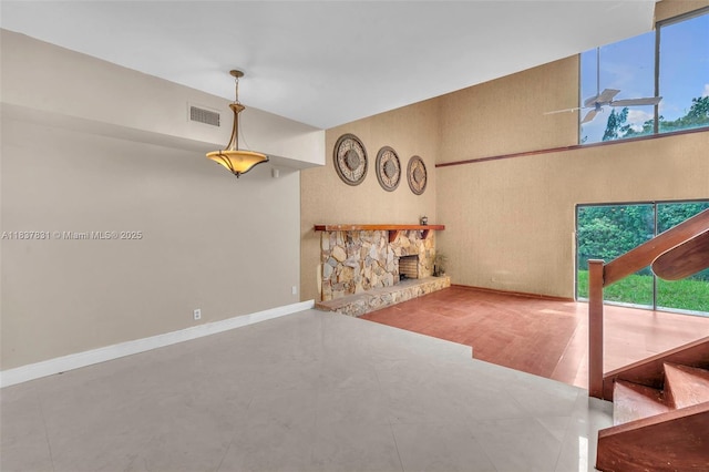 911 Mockingbird Ln, Plantation, FL 33324 - unfurnished living room featuring plenty of natural light, a towering ceiling, and a stone fireplace