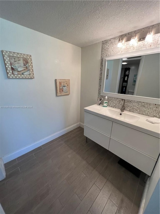 16171 Blatt Blvd Unit 104, Weston, FL 33326 - bathroom featuring wood finished floors, vanity, a textured ceiling, and decorative backsplash