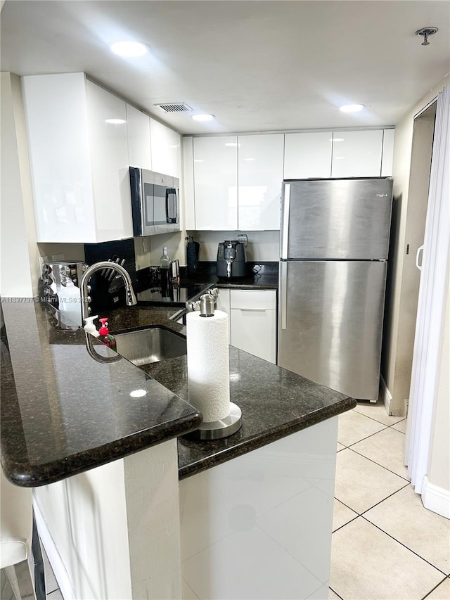 2351 Douglas Rd Unit 702, Miami, FL 33145 - kitchen featuring stainless steel appliances, modern cabinets, a peninsula, white cabinetry, and dark stone countertops