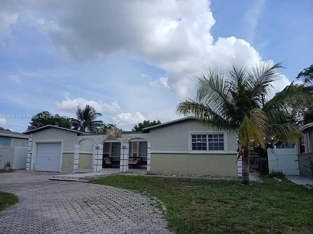 7745 Harbour Blvd, Miramar, FL 33023 - view of front of home with stucco siding, decorative driveway, an attached garage, and a gate