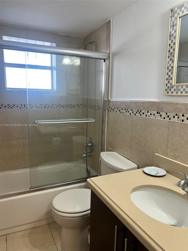 1200 14th St Unit 3C, Miami Beach, FL 33139 - full bathroom with bath / shower combo with glass door, vanity, tile patterned flooring, tile walls, and wainscoting
