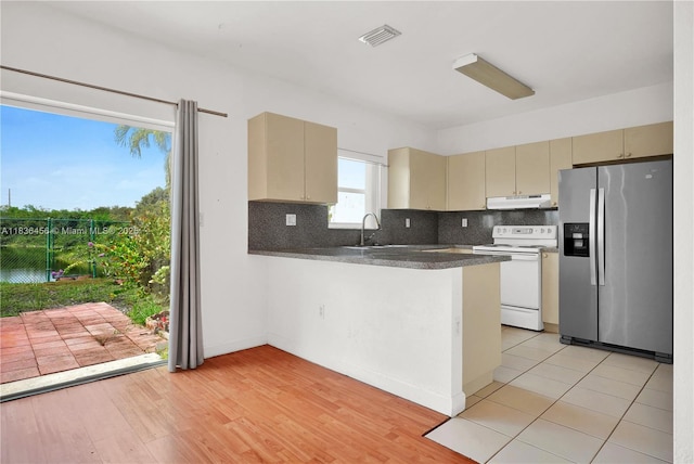 14815 SW 9th Ln, Miami, FL 33194 - kitchen featuring stainless steel fridge with ice dispenser, electric stove, under cabinet range hood, cream cabinets, and dark countertops