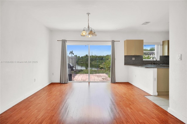 14815 SW 9th Ln, Miami, FL 33194 - unfurnished living room with a chandelier, light wood-style floors, and a water view