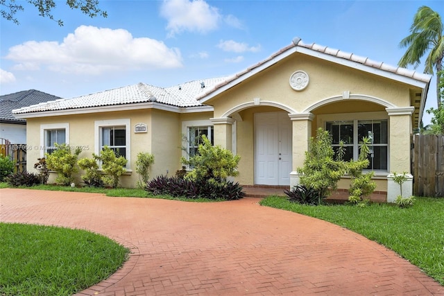 8899 NW 169th Ter, Hialeah, FL 33018 - view of front of house featuring stucco siding, curved driveway, and a tiled roof