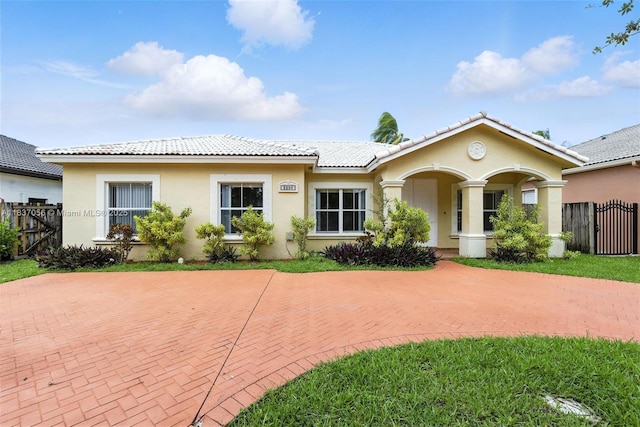 8899 NW 169th Ter, Hialeah, FL 33018 - ranch-style house with stucco siding, a tile roof, a gate, and curved driveway
